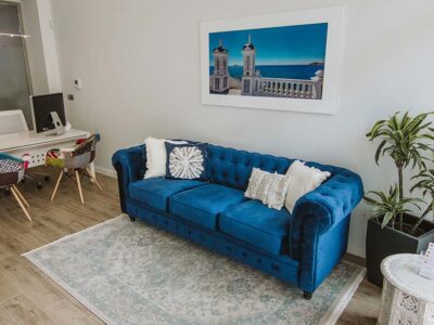 Sofá azul y zona de recepción Oficina Albir Abogado Inmobiliaria Costa Blanca