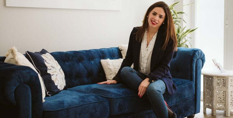 smiling woman on blue sofa of financial advice in Spain offices in Albir